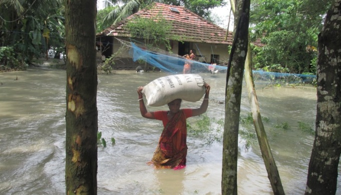 <p>A resident of Sagar island is able to save just one bag of wheat as she is forced out of her home by the high tide.</p>