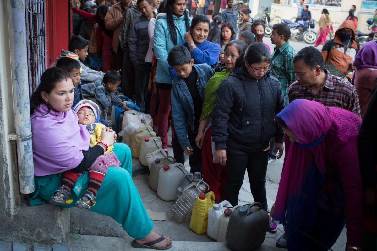 A woman with a baby waits in a queue for kerosene oil in Kathmandu. She waited 24 hours for 3 litres of cooking oil. 