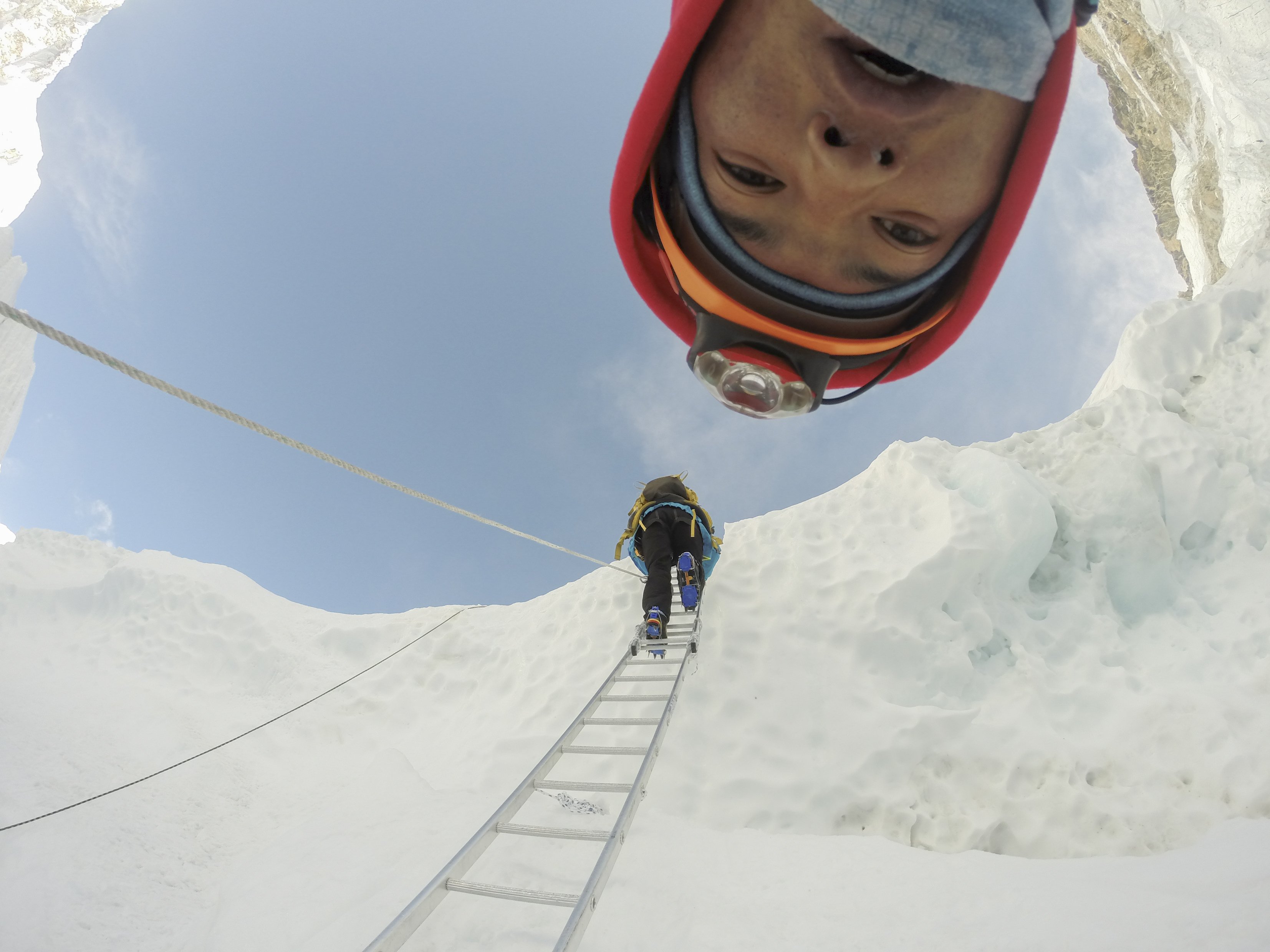 Sherpa climbing up a ladder Mount Everest