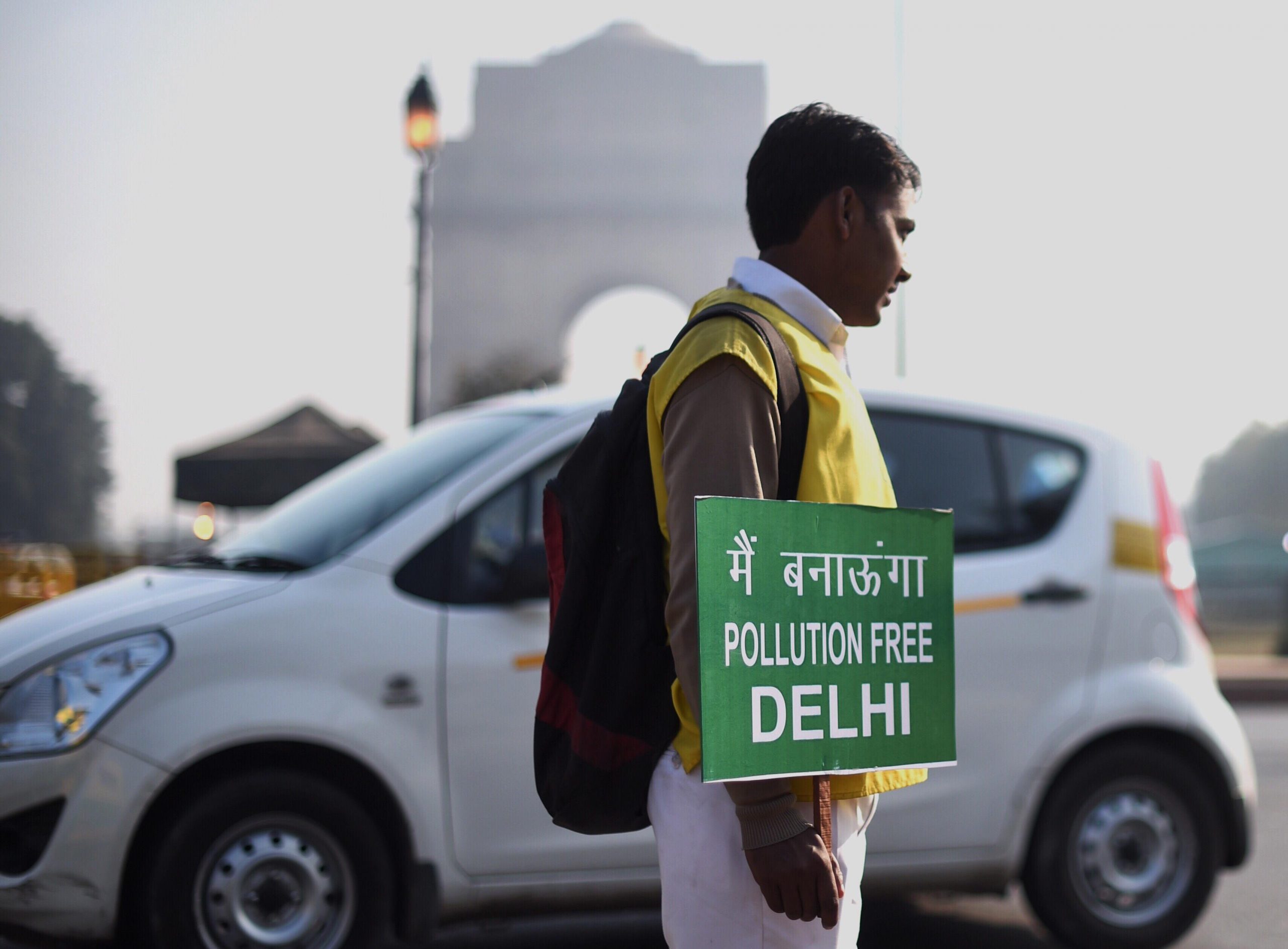 civil defence volunteer holds a placard saying 'Pollution free Delhi'