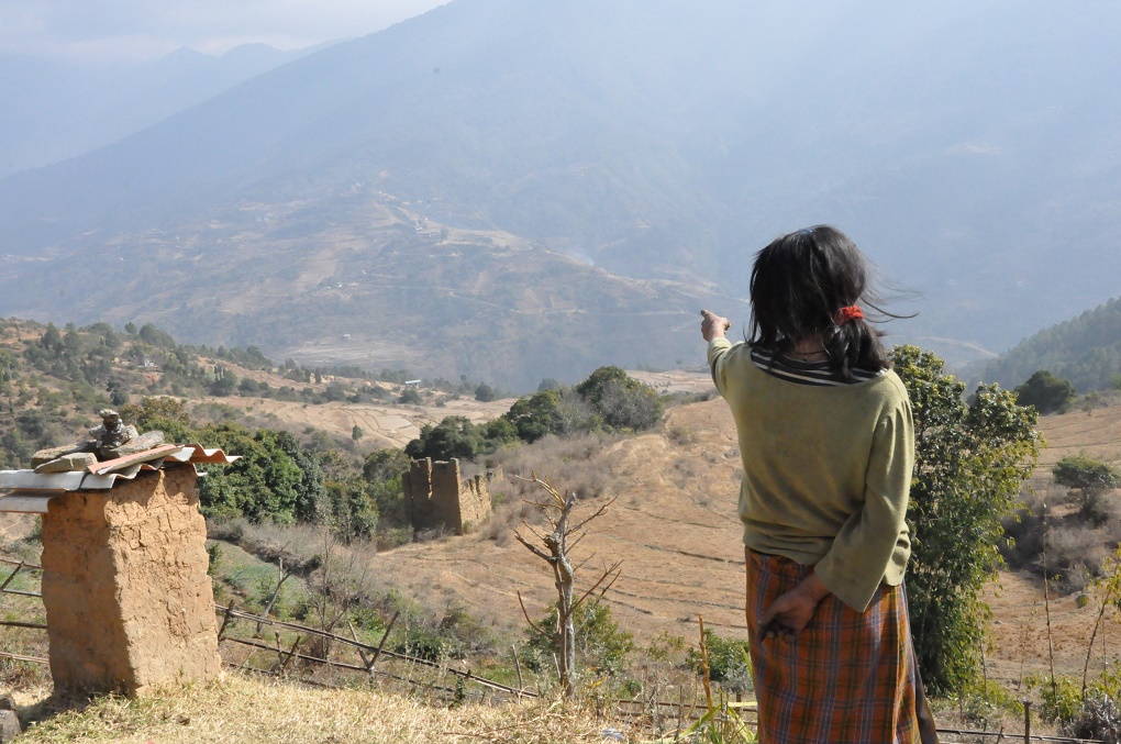 A landowner gestures at her dry fields, left fallow, Bhutan [image by Dawa Gyelmo]