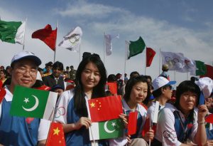 People hold flags of China and Pakistan during the Olympic torch ceremony in Islamabad