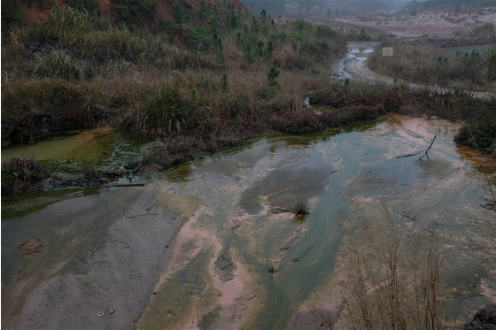 <p>When it rains untreated residual chemicals from an abandoned rare earths leaching pond flow into Ganzhou&#8217;s surface water. (Image by Liu Hongqiao)</p>