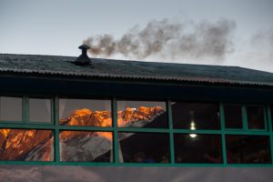 <p>Smoke emitted from a hotel in Debuche as the sun sets over Mount Everest. Recent studies show that black carbon from such smoke is causing faster retreat of the glaciers in Himalaya Region [image by: Nabin Baral]</p>
