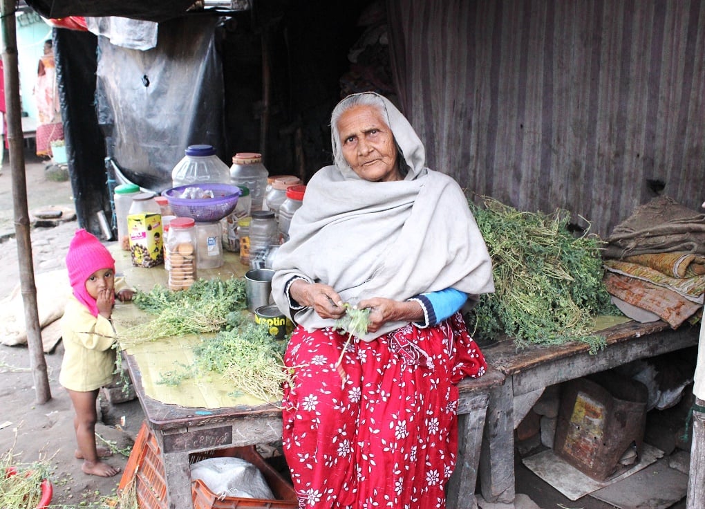 <p>75-year-old Afsa Begum sells biscuits and fryums for kids who come to study in the madrasa housed in a crumbling 15th century mosque complex on the outskirts of Patna, Bihar, where she, her daughter-in-law and two-year-old granddaughter have squatted since years. Her husband is dead and her son left for Mangalore to work for a construction contractor after the severe monsoon floods in 2016. He has sent money only once [image by Manipadma Jena]</p>