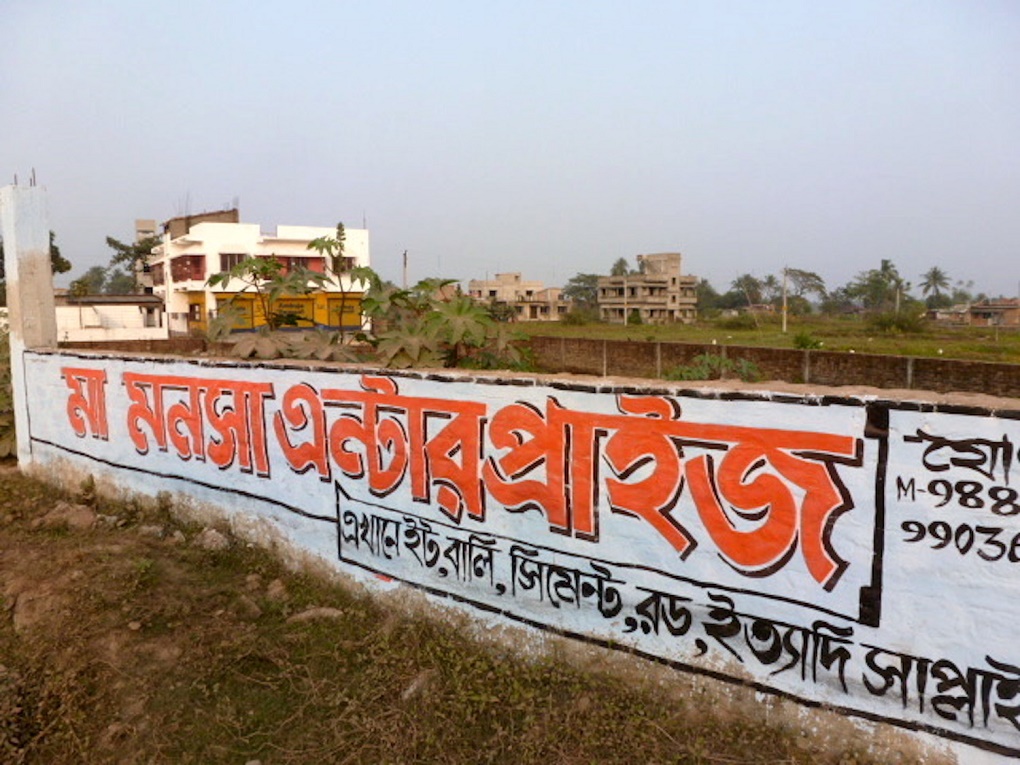 <p>An advertisement for building material in the backdrop of new residences coming up in the Kolkata wetlands [image by Soumya Sarkar]</p>