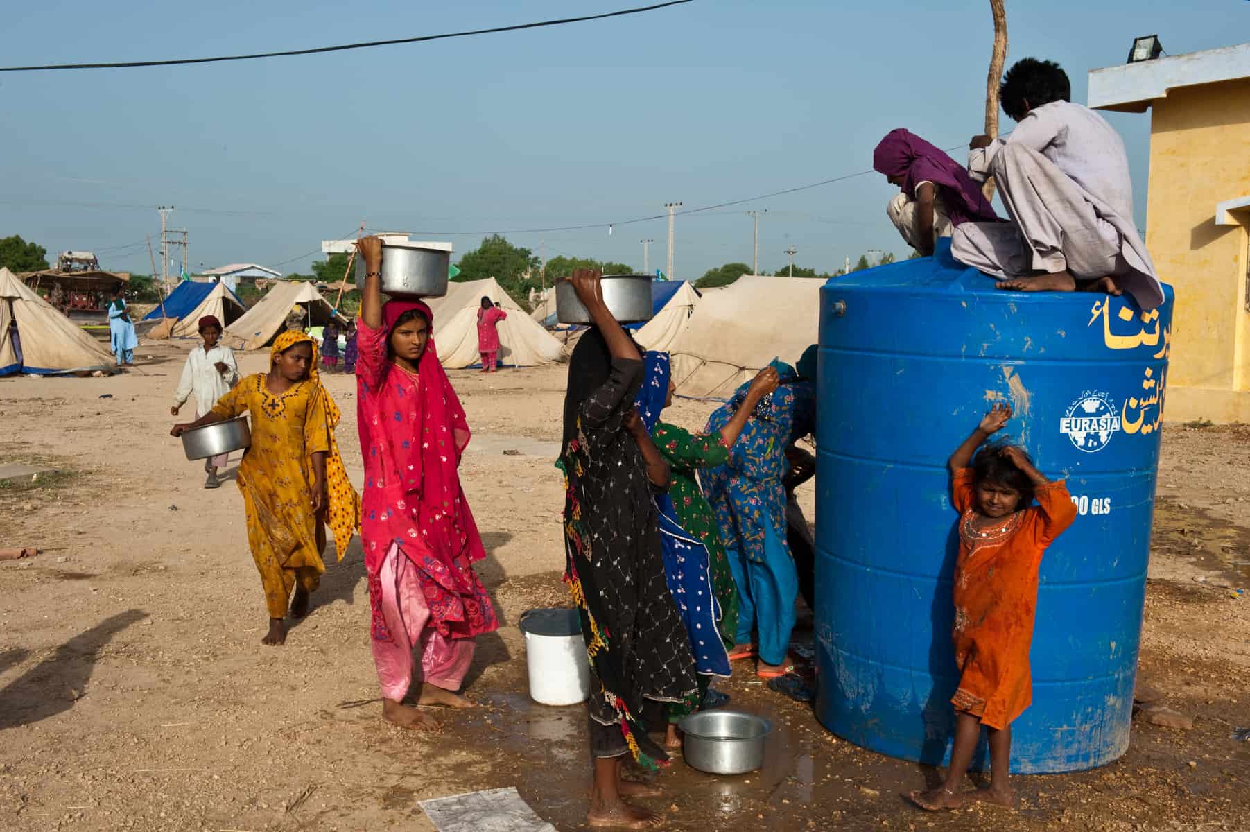 <p>Water being distributed to displaced people taking refuge at the Makli Graveyard, Thatta, Pakistan [image courtesy: ADB]</p>