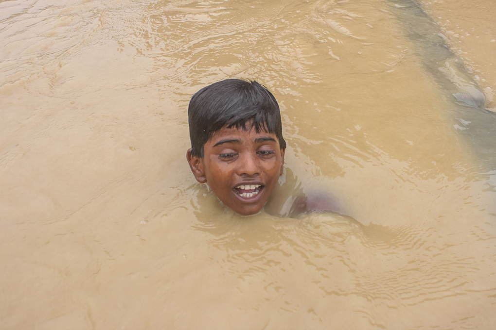 <p>A boy swims through a flooded street in Ramgaduwa in southern Nepal [image by Munna Saraff]</p>