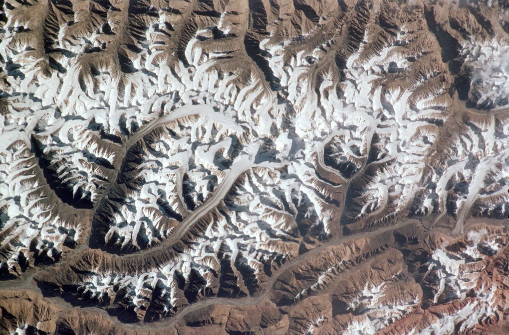 <p>An aeriel view over glaciers in the Karakoram Mountain range [Credit: NASA Johnson]</p>