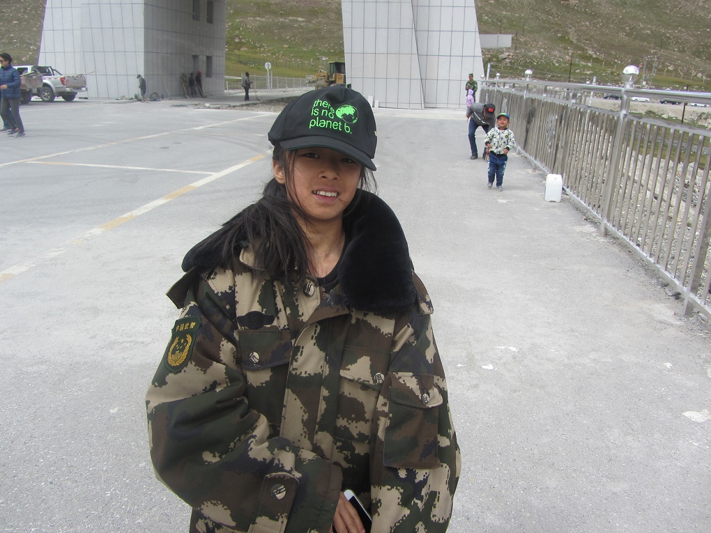 A young Chinese girl wearing a baseball cap with the message 'there is no planet b'