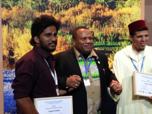 <p>Adarsh Prathap (left) after receiving the top award from Inia Seruiratu, Minister for Agriculture in Fiji and the country’s climate champion (centre) (Image by Joydeep Gupta)</p>