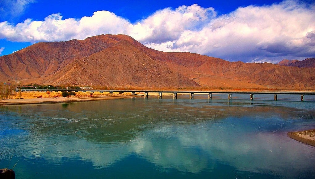 <p>A bridge over the Yarlung Zangbo/Yarlung Tsangpo river west of Lhasa. The river later flows into India where it is known as the Brahmaputra [image by Eric/Flickr]</p>
