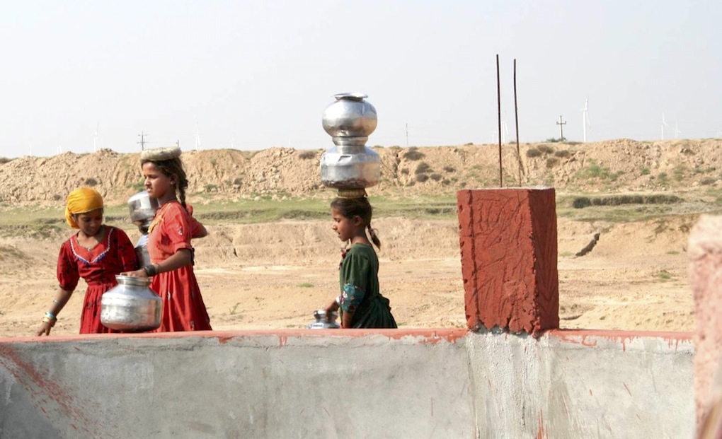 <p>Young girls at a well in Gujarat, which is already facing a water scarcity [image by: Mark Charmer]</p>