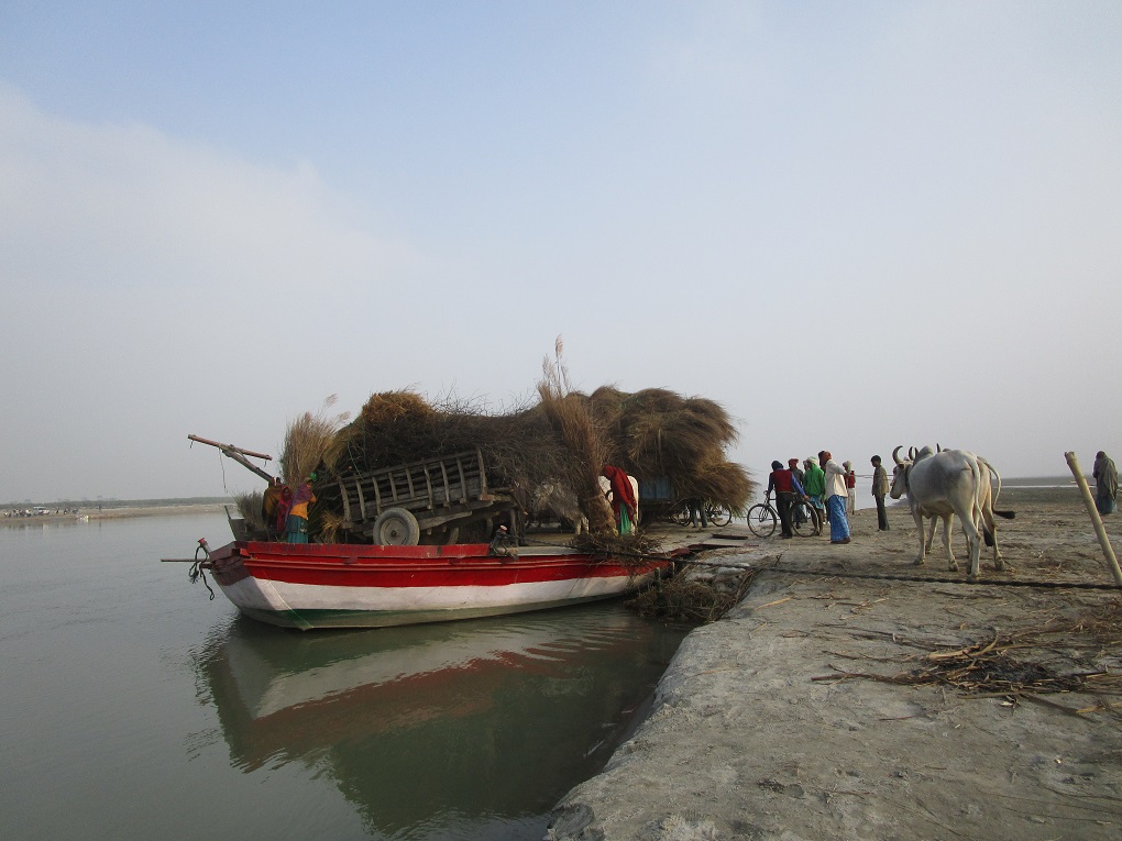 large boat carrying silt to the bank of Gandak river where people are awaiting