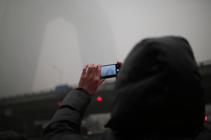 Beijing resident taking a picture of smog in China
