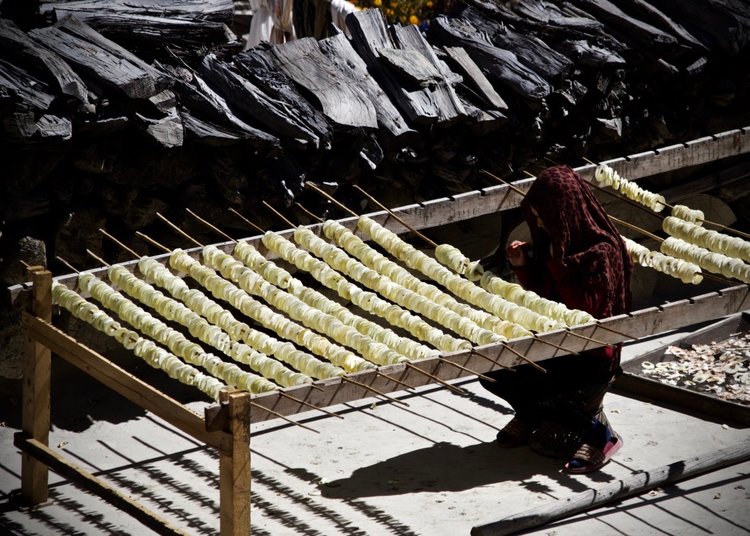 A woman lays out apples to dry in Mustang [image by: Yolanda Clatworthy]