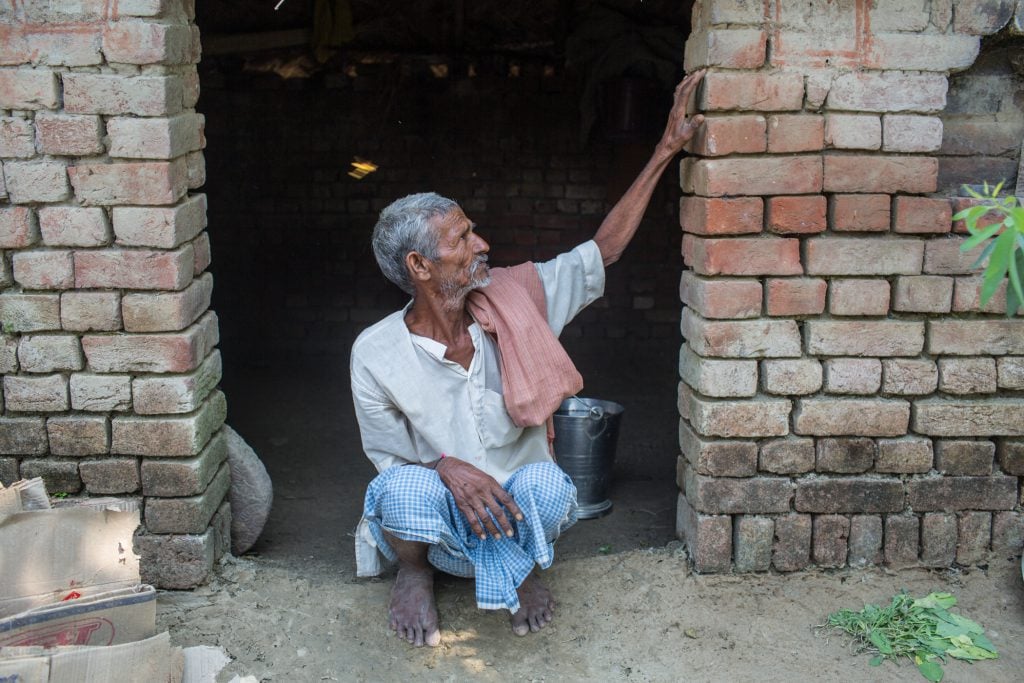 Chandra Vahal, a flood victim in Jogapurwa village in Bahraich district of Uttar Pradesh state, showing the level of the flood waters that submerged his make shift houses by last monsoon [image by: Nabin Baral]