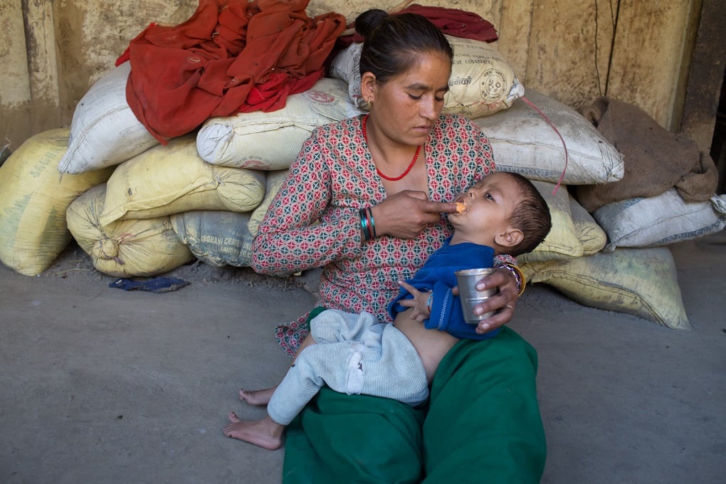 mother feeding her malnourished child 