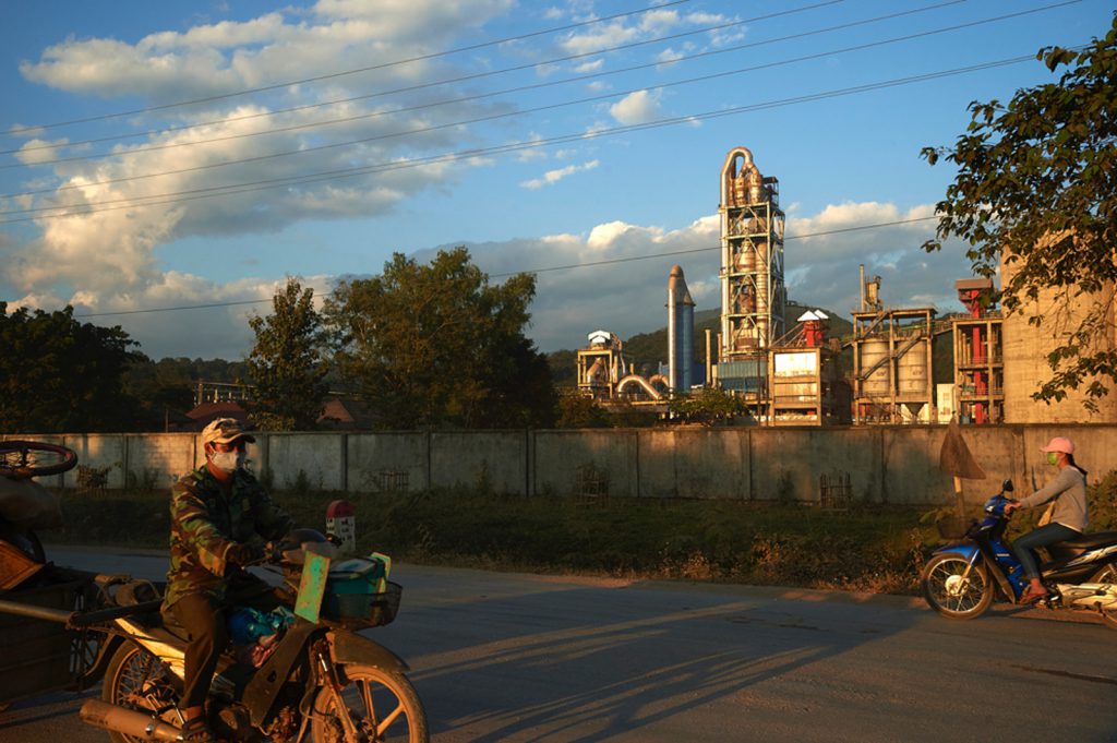 man on a motorbike outside the Vang Vieng cement factory