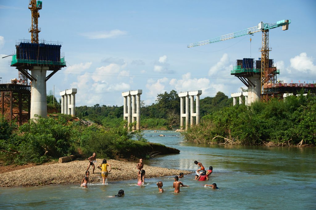 Twelve children playing by the Nam Like River bridge in Vientiane province. Some of the children are swimming in the lake
