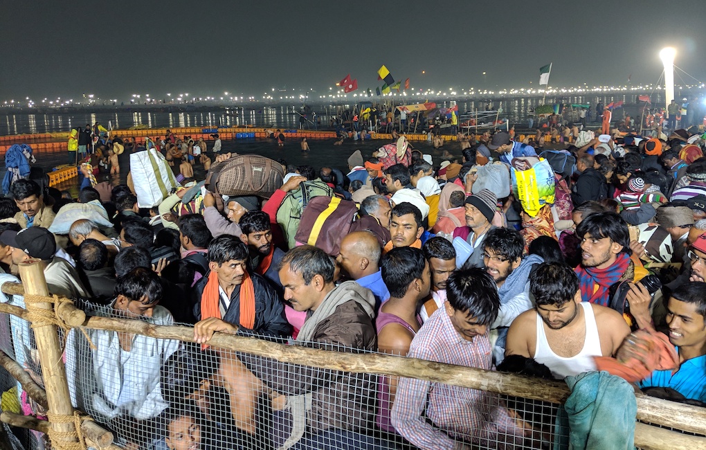 pilgrims crowded at the confluence of the Ganga, waiting to take a holy dip