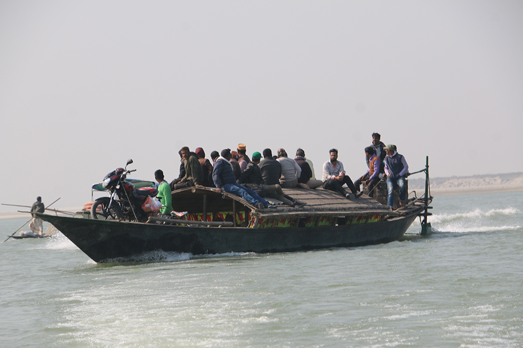 several people on a boat travelling along the Brahmaputra river 