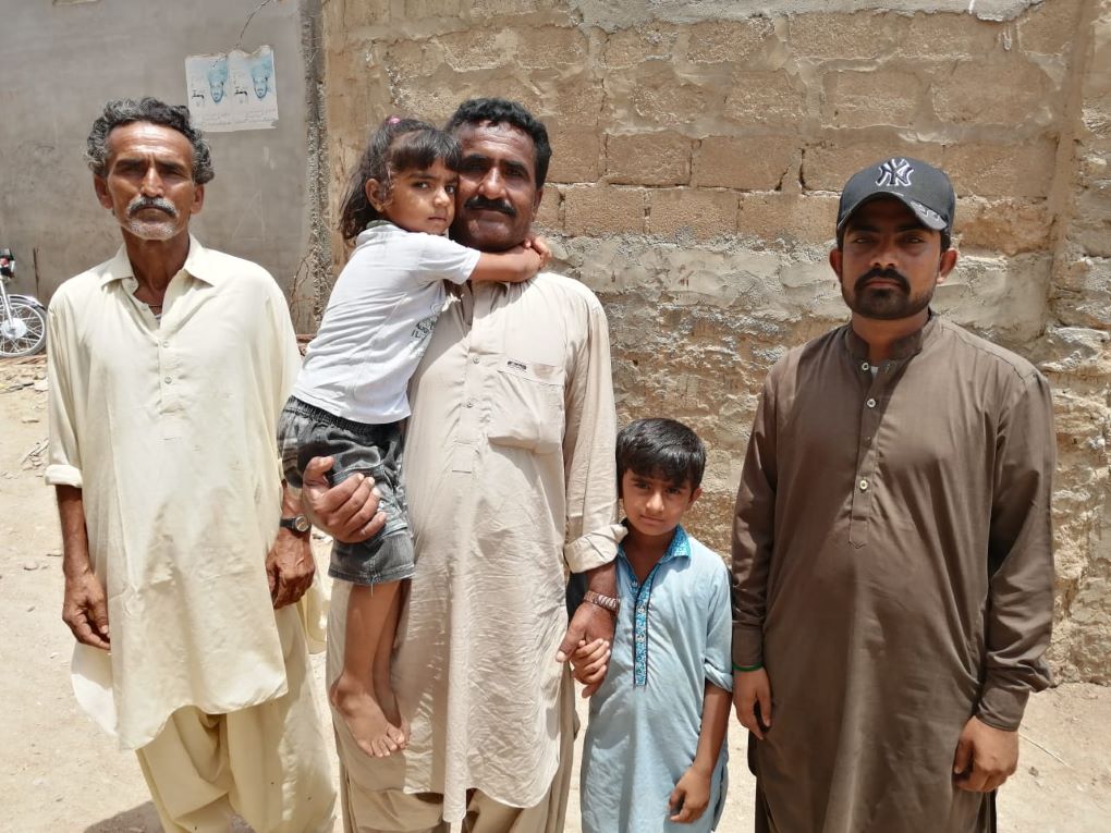 <p>Nazeer Mirbaher (centre) is one of the half million people who have had to flee homes drowned by encroaching sea water [image by: Shahid Shah]</p>