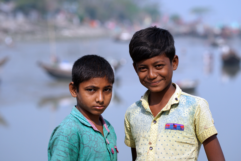 Nayon and Suman standing together on the pier. Noyons family catch and sell wild fish, whilst Suman's father is a labourer.  [image by: Mohammad Arju]