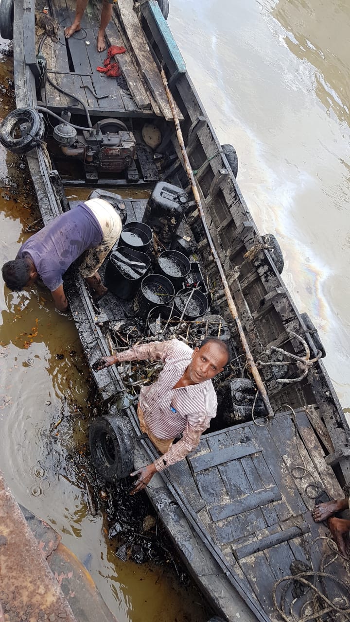 Two men undertaking a cleaning operation following the Bangladesh oil spill 