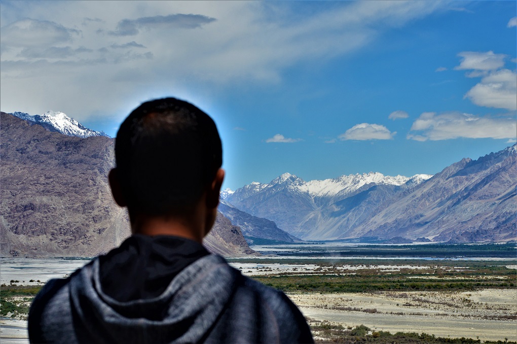 A local in the Nubra Valley of Ladakh, looking towards the Korakoram mountain range, which hosts the Siachen Glacier [image by: Athar Parvaiz]
