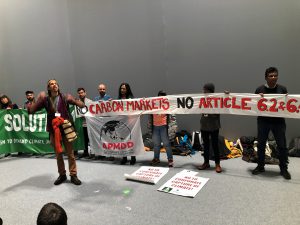 <p>Climate activists, who say carbon markets encourage developed countries to pollute, demonstrating at the Madrid climate summit [image by: Joydeep Gupta]</p>