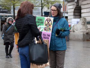 <p>A campaigner informs a pedestrian about extinction level threats [image by: kthtrnr/Flickr]</p>