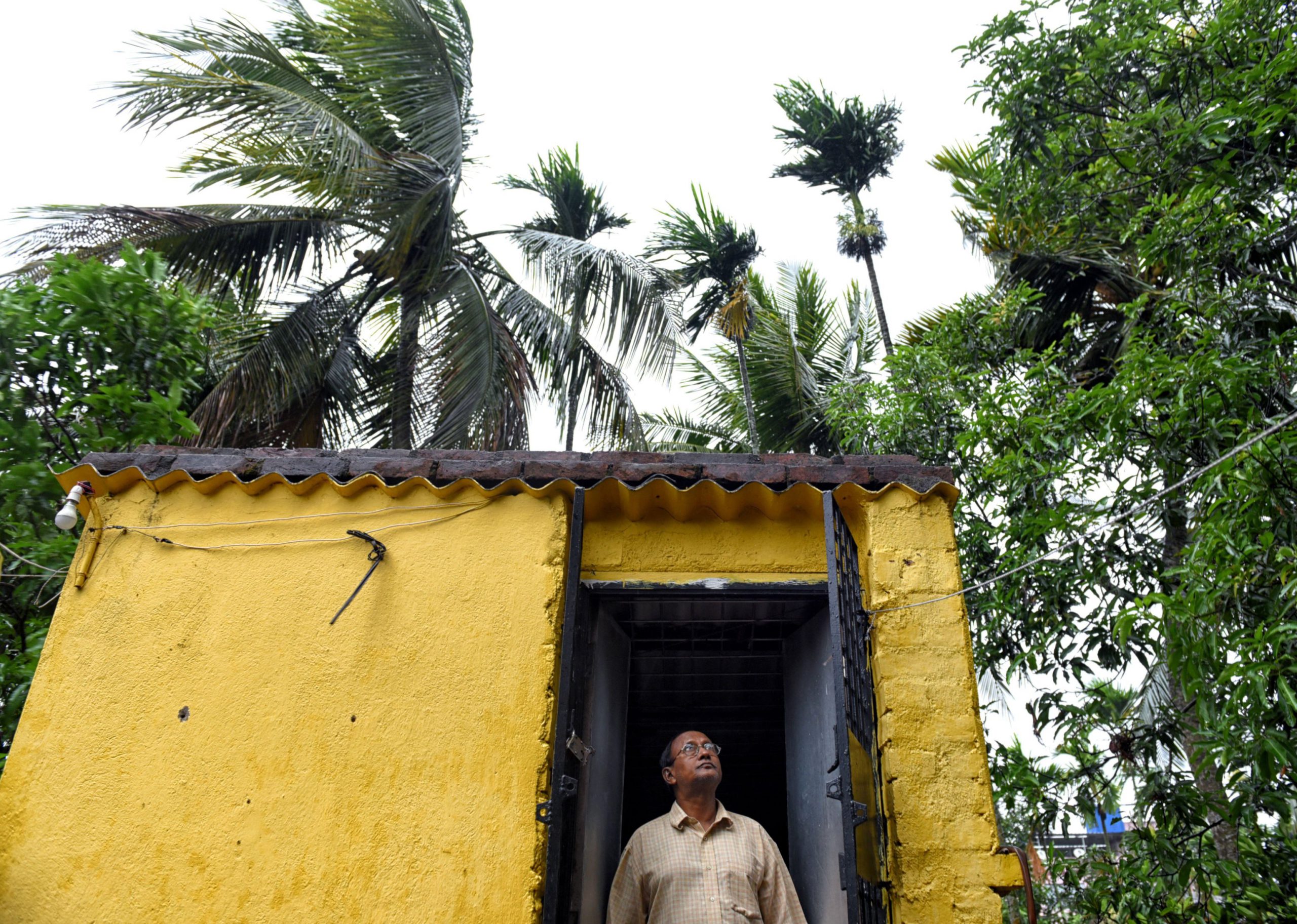A man is seen looking up at the sky from his doorway before the hit of the Cyclone Amphan.Super Cyclone Amphan hits West Bengal with a speed of 130 kmph on the afternoon of 20th May [image: Alamy]
