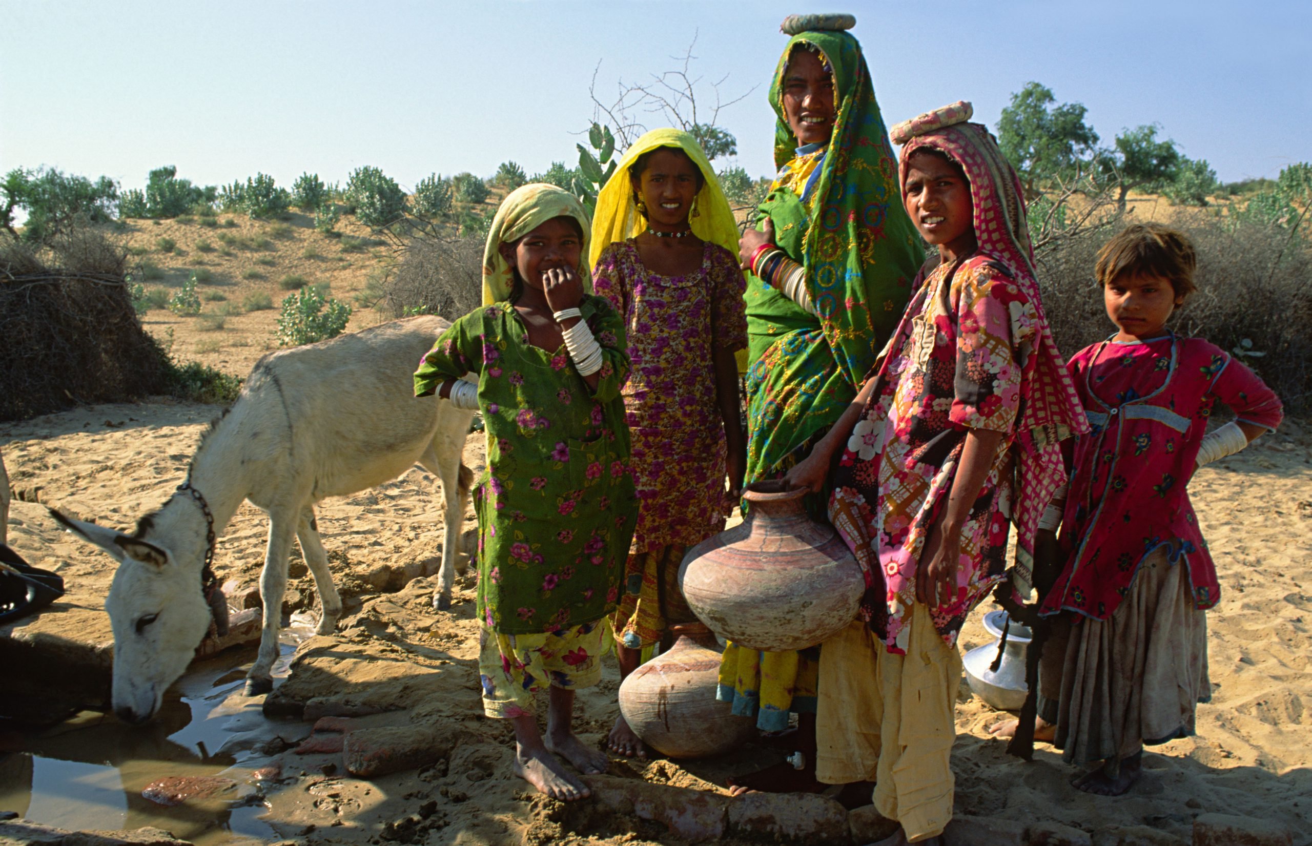 Mother and daughters collecting water from the village well in the arid region of Thar desert, Pakistan Sindh province.