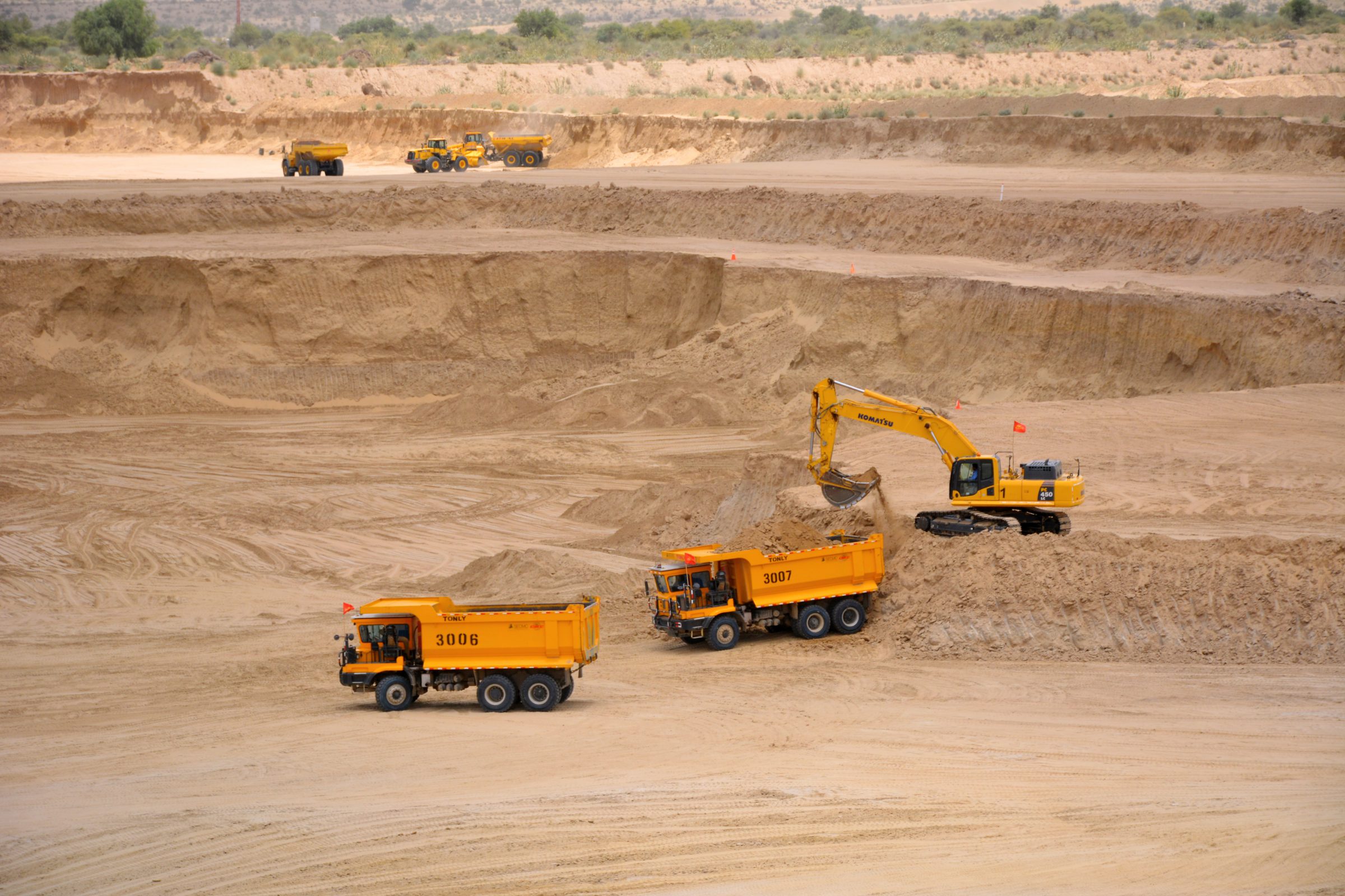 3 orange trucks coal mining in Thar desert, Pakistan