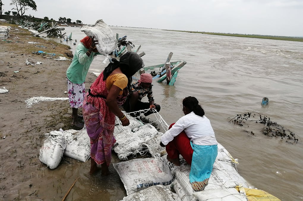 <p>Residents of Thakurbari place sand-filled bags on the Koshi riverbank in an effort to save the riverbank and their homes from floodwaters [Image by: Birat Anupam]</p>