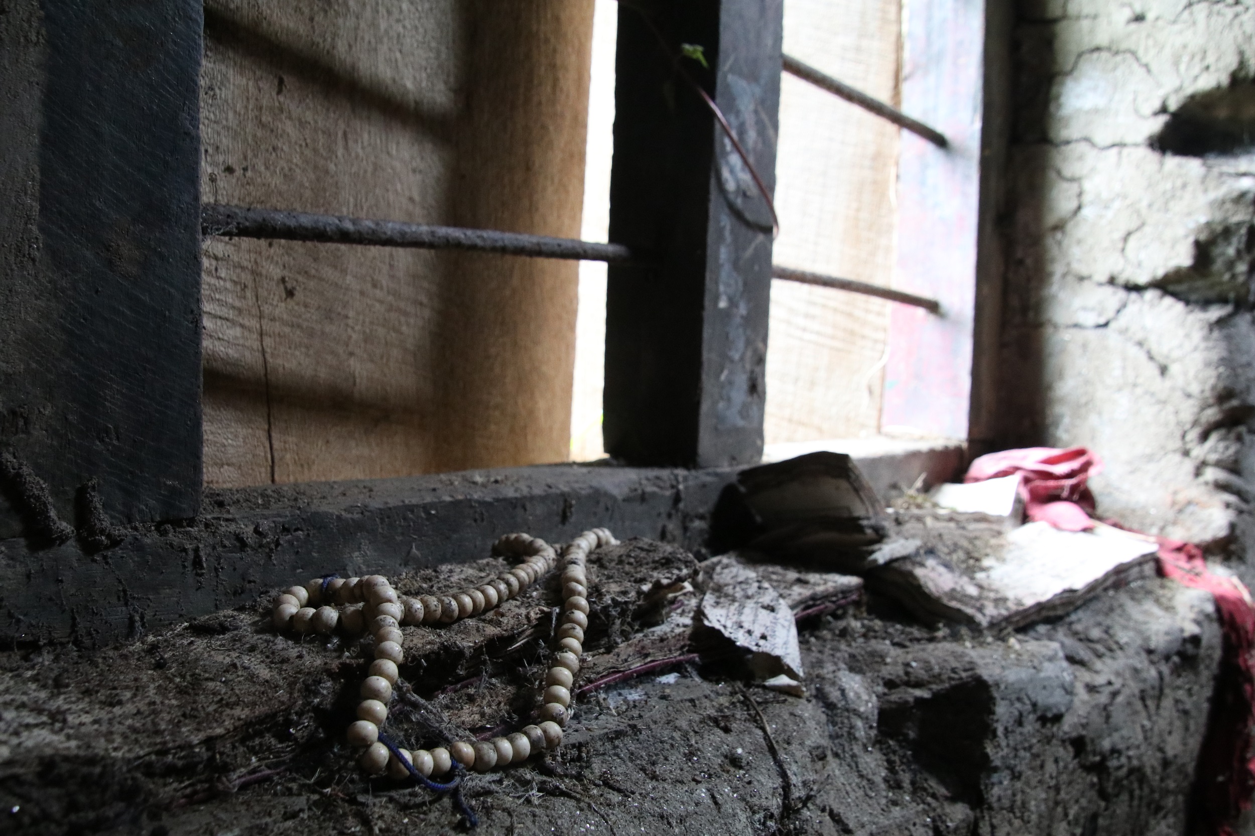 Prayer beads and prayer books near a window in an abandoned house in Shamdoley, Dagana district
