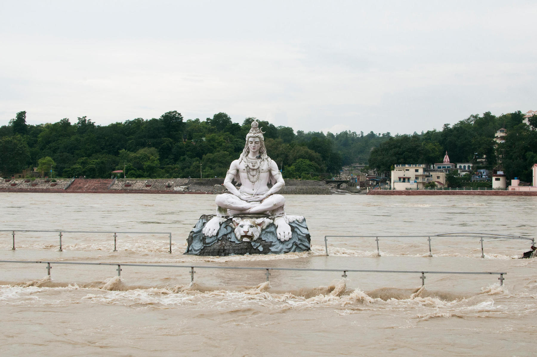 <p>A statue of the Hindu god Shiva in the middle of the Ganga river, which overflowed due to heavy rains in Rishikesh, Uttarakhand, in 2011 [image by: Scarabea / Alamy]</p>