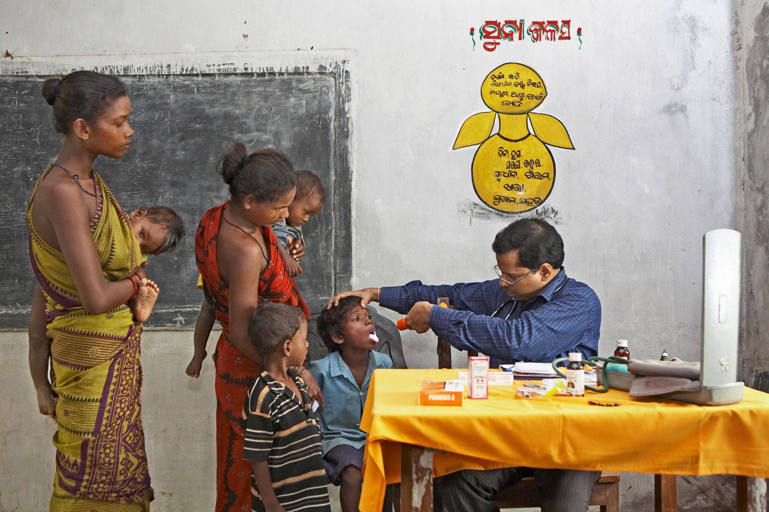 Doctor examining health of poor villagers at health check up camp initiative started by NGO Chinmaya Organization India