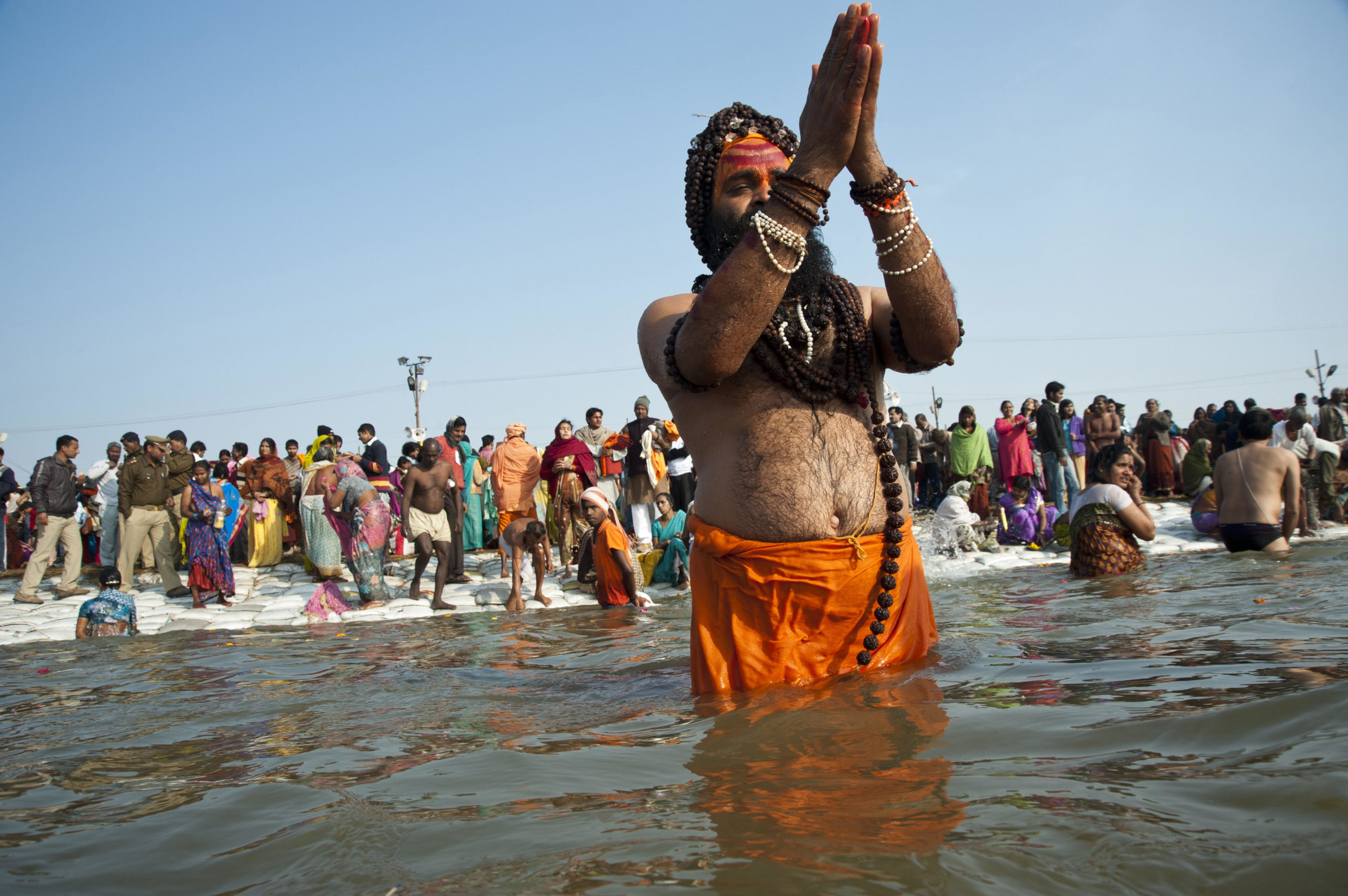 <p>A Sadhu praying to the sun in the Ganga river at the 2013 Kumbh Mela at Allahabad, India. [Image: Alamy]</p>