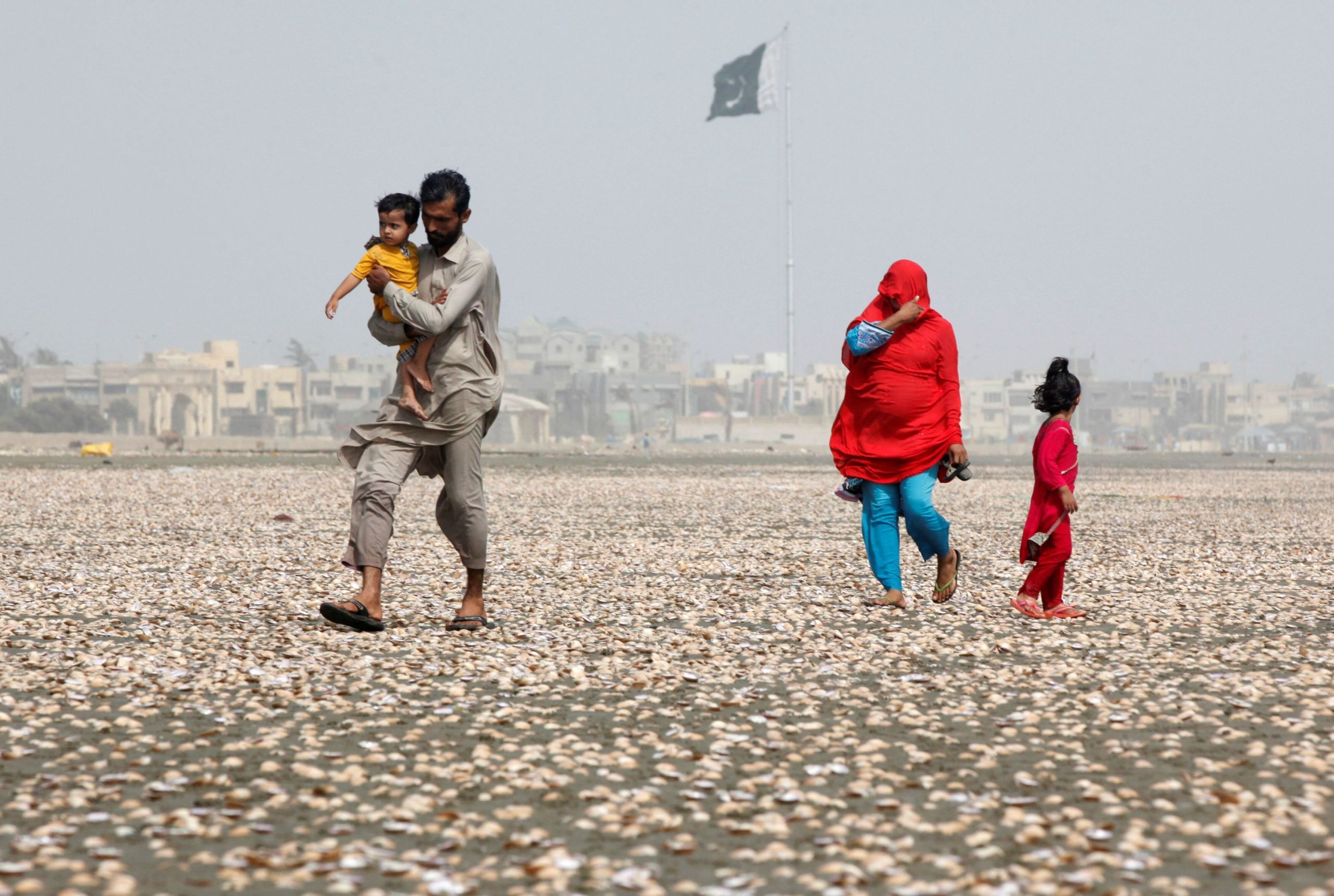 <p>A family walk along the beach on a hot day in Karachi, Pakistan, in May 2016 (Image: Reuters/Akhtar Soomro)</p>
