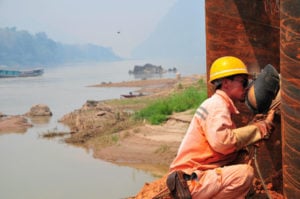 <p>A Chinese welder at work on a bridge over the Mekong, part of the China–Laos high-speed railway (Image: Alamy)</p>