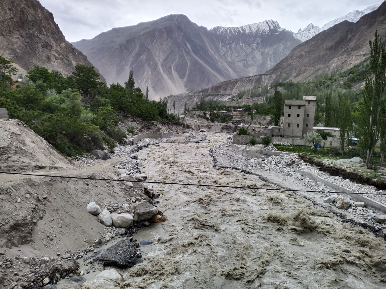 <p>Homes, agricultural land and thousands of trees were threatened when flood water roared downstream from the Shishper glacier and a glacial lake towards the village of Hassanabad in late May (Image: Tariq Jamil)</p>
