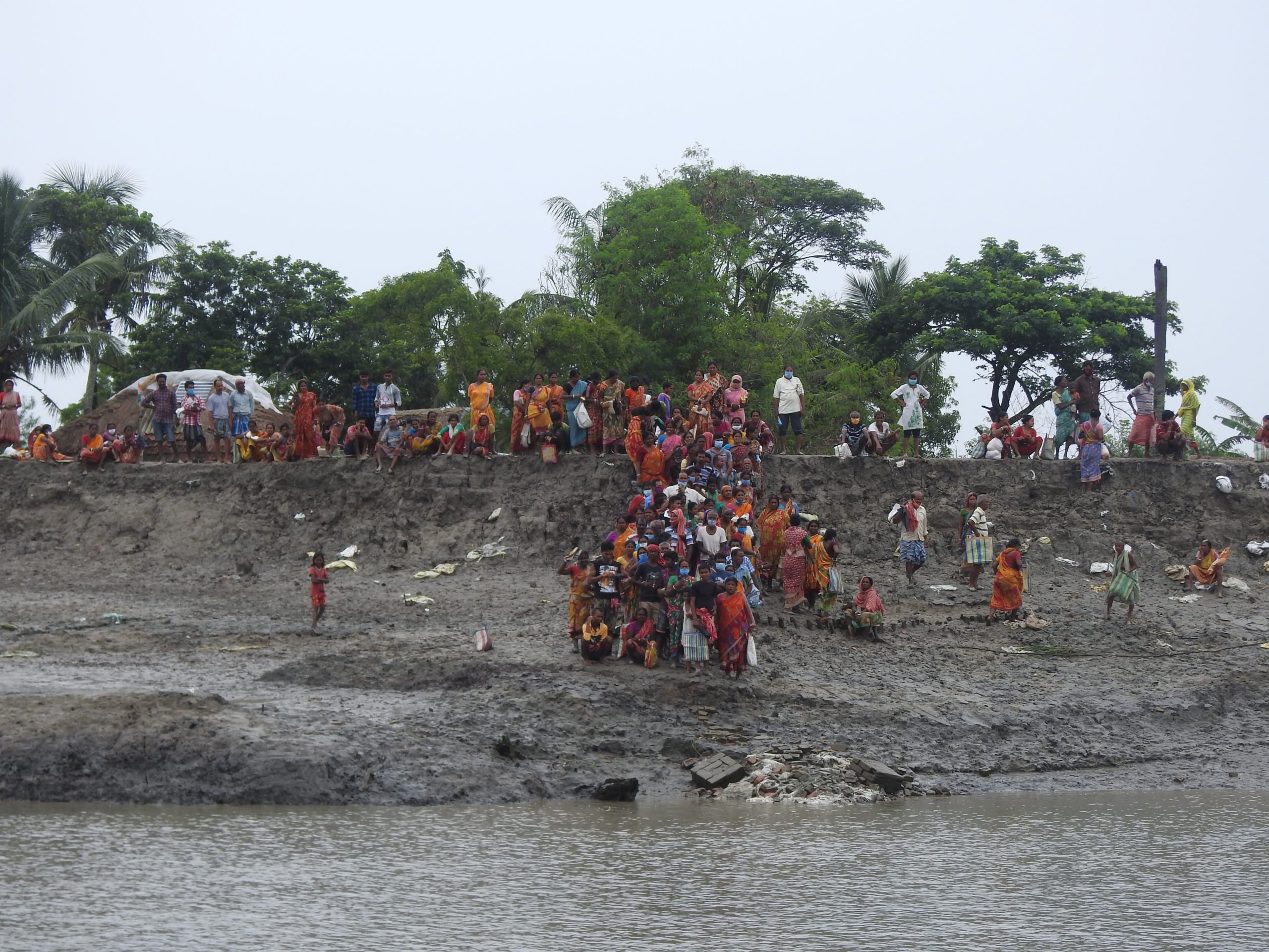 <p>In the wake of Cyclone Yaas, residents scramble over a broken embankment (Image: Medha Basu)</p>