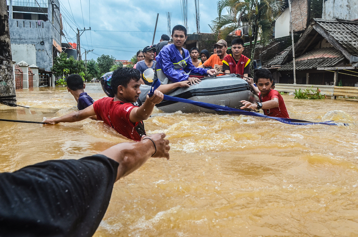 Rescuers evacuate residents from their flooded houses in Paccerakkang, Makassar, South Sulawesi, Indonesia