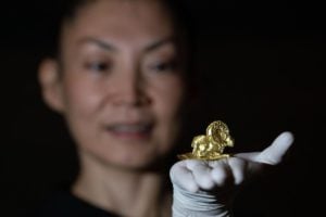 <p>Curator Saltanat Amirova holds a gold argali (wild mountain sheep) from the ‘Gold of the Great Steppe’ exhibition at the Fitzwilliam Museum in Cambridge. The exhibition contains thousands of gold artefacts from the burial mounds of the Saka people of eastern Kazakhstan. (Image: PA Images / Alamy)</p>