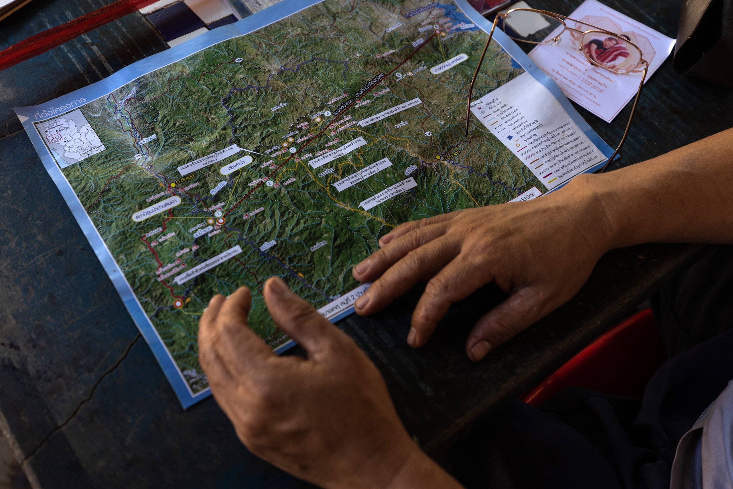 Thongchai Leawpichaipaibul, 52, a shop owner in Mae Ngaw, looks at a map of the diversion tunnel.
