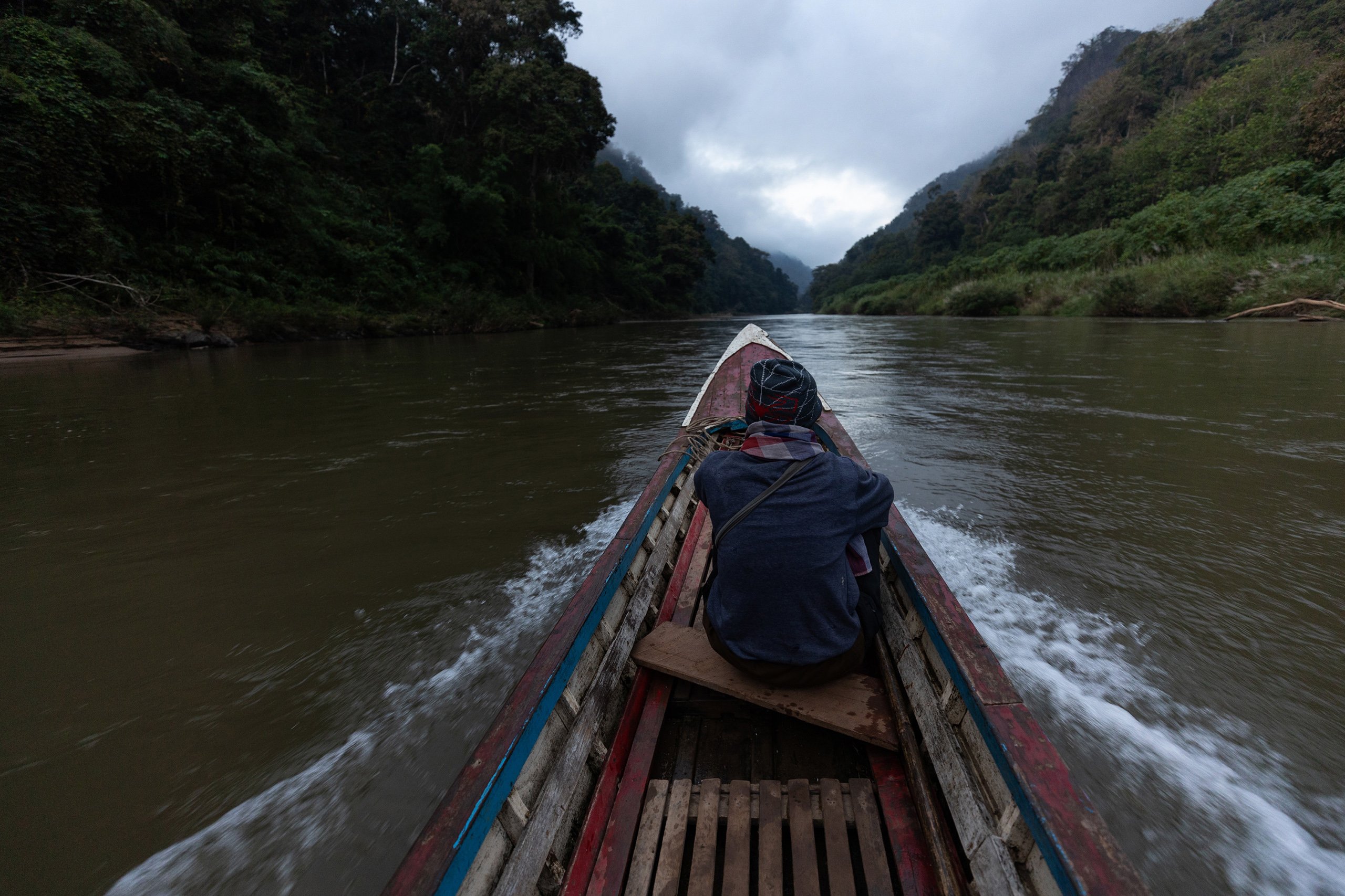 Singhkan Ruenhom, who’s father founded Mae Ngaw village, sits in a boat on the Yuam River.