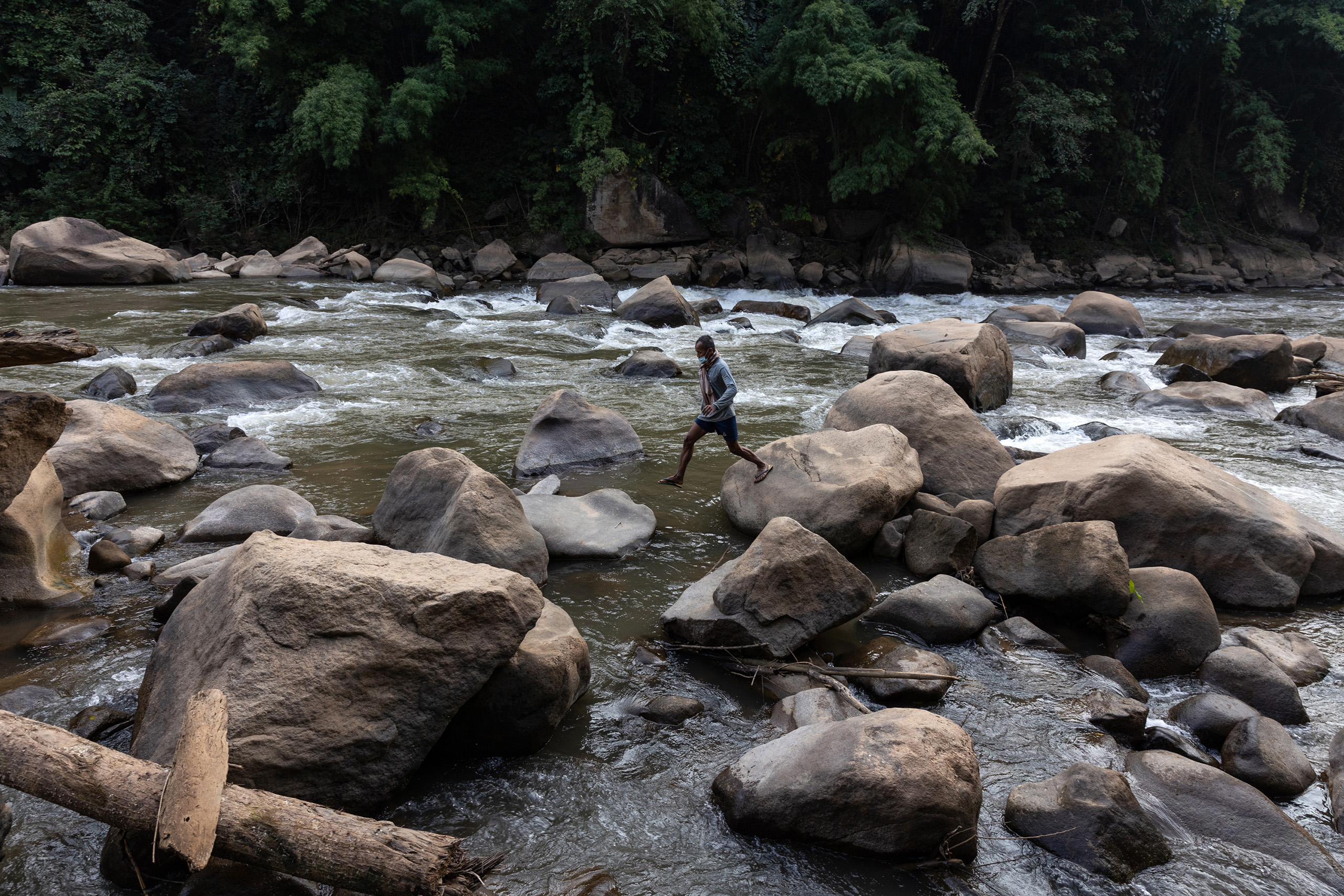 Prayot Kuenkaew who lives in Mae Ngaw village, jumps on rocks on the River Yuam