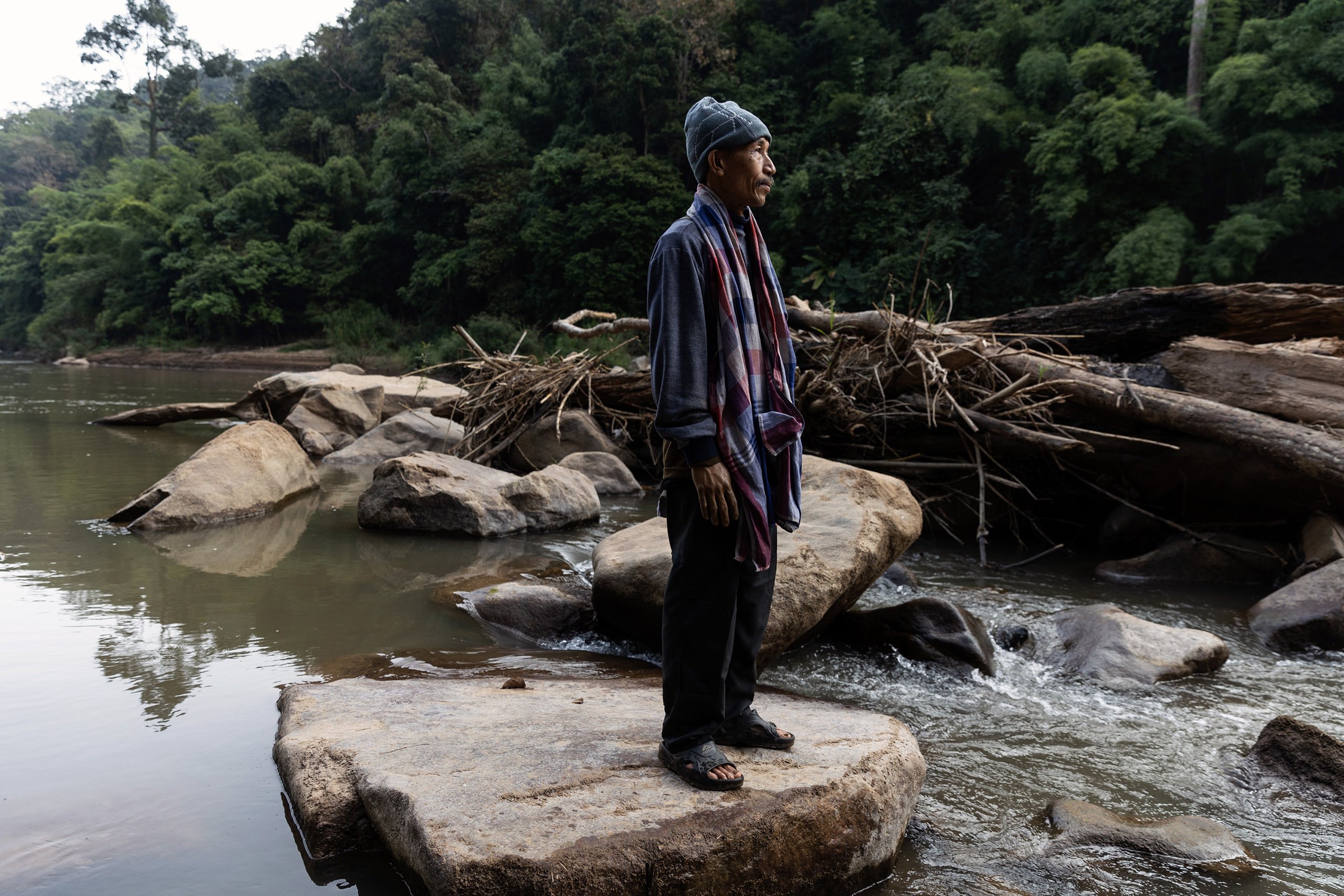 Singhkan Ruenhom of Mae Ngaw village, stands on rocks on the River Yuam,